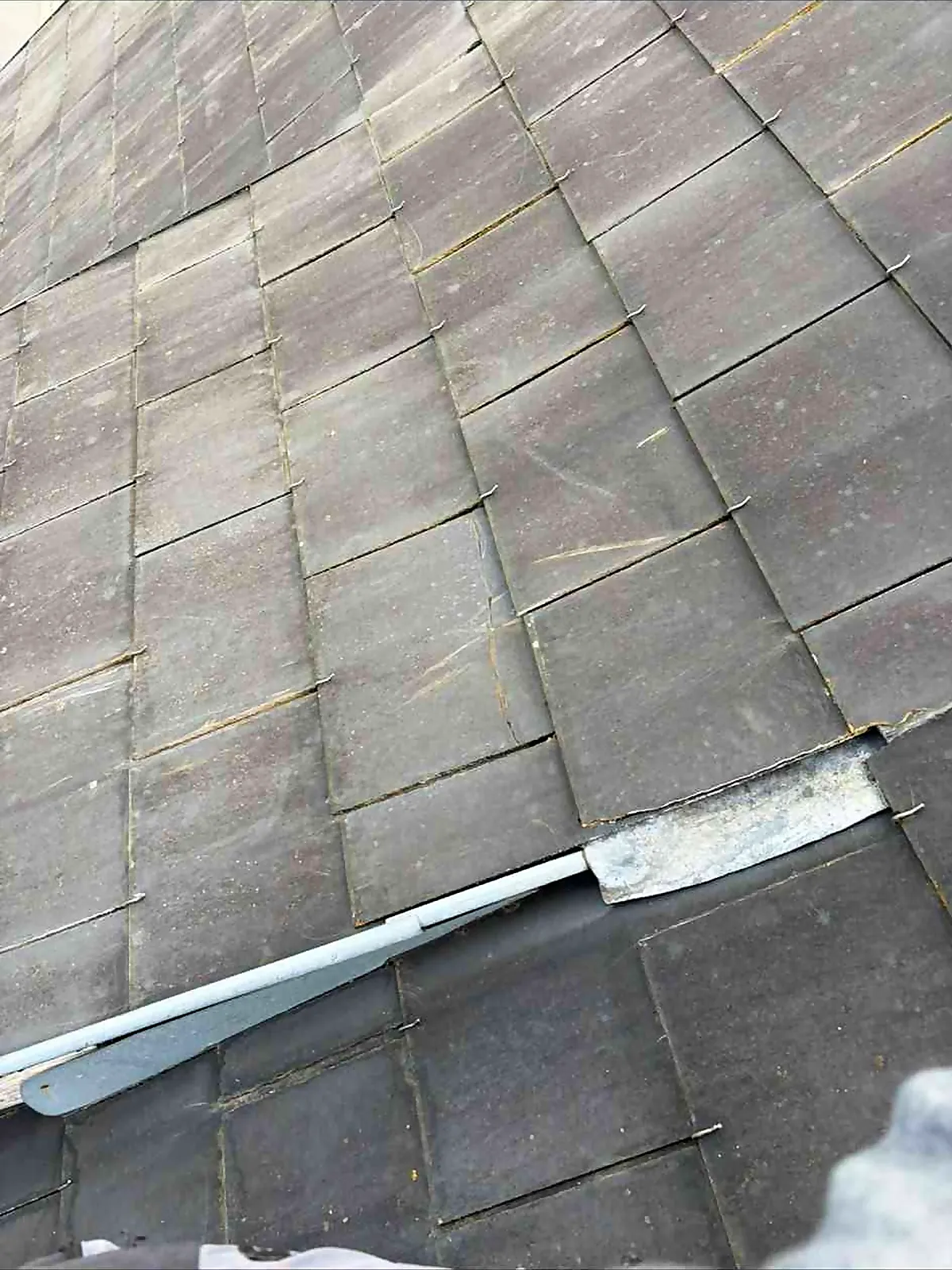 Détail d'une couverture en ardoises et de sa bande métallique au Grand-Quevilly