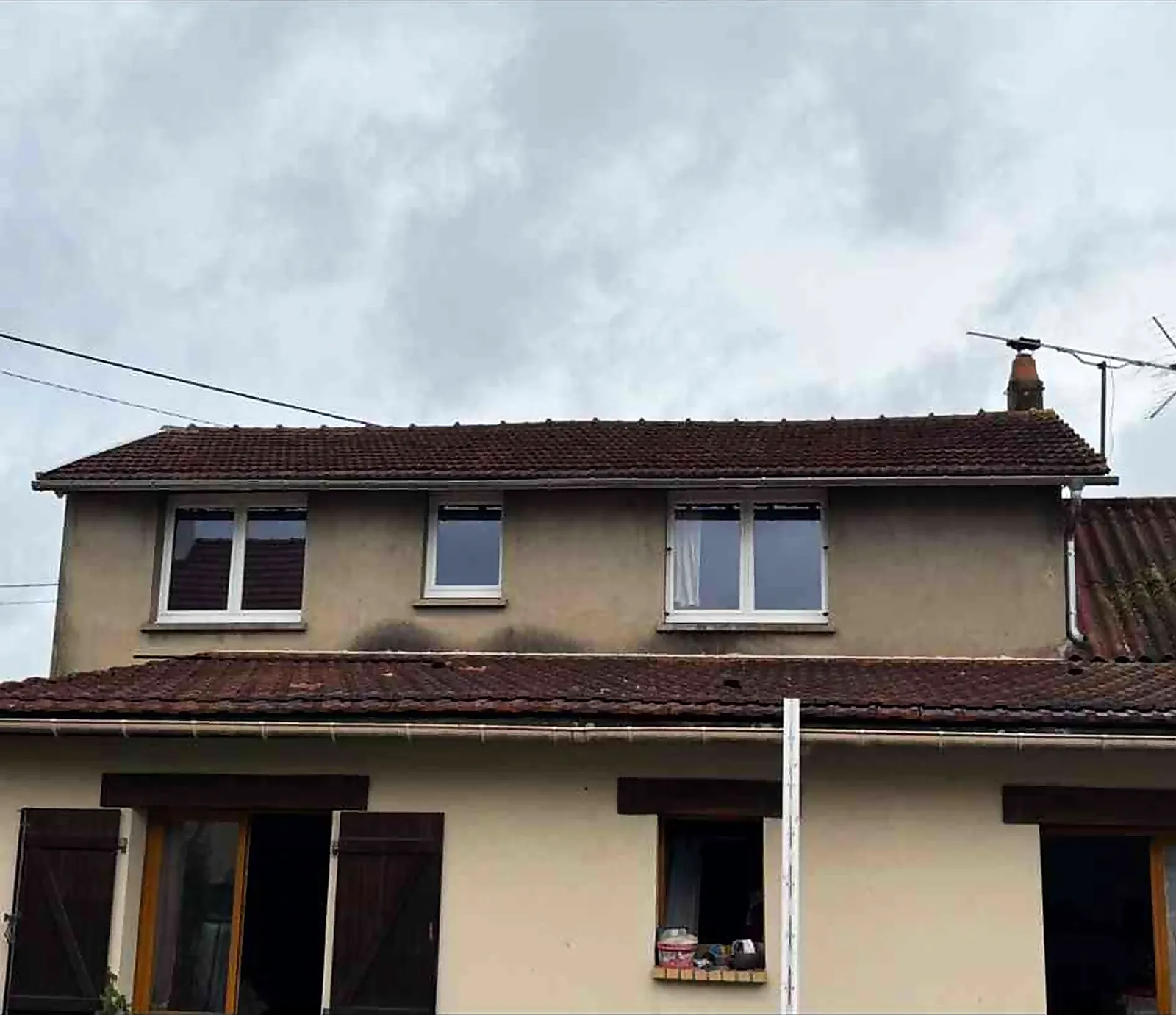 Façade et bas de toiture d'une maison avant le remplacement de gouttière à Saint-Étienne-du-Rouvray