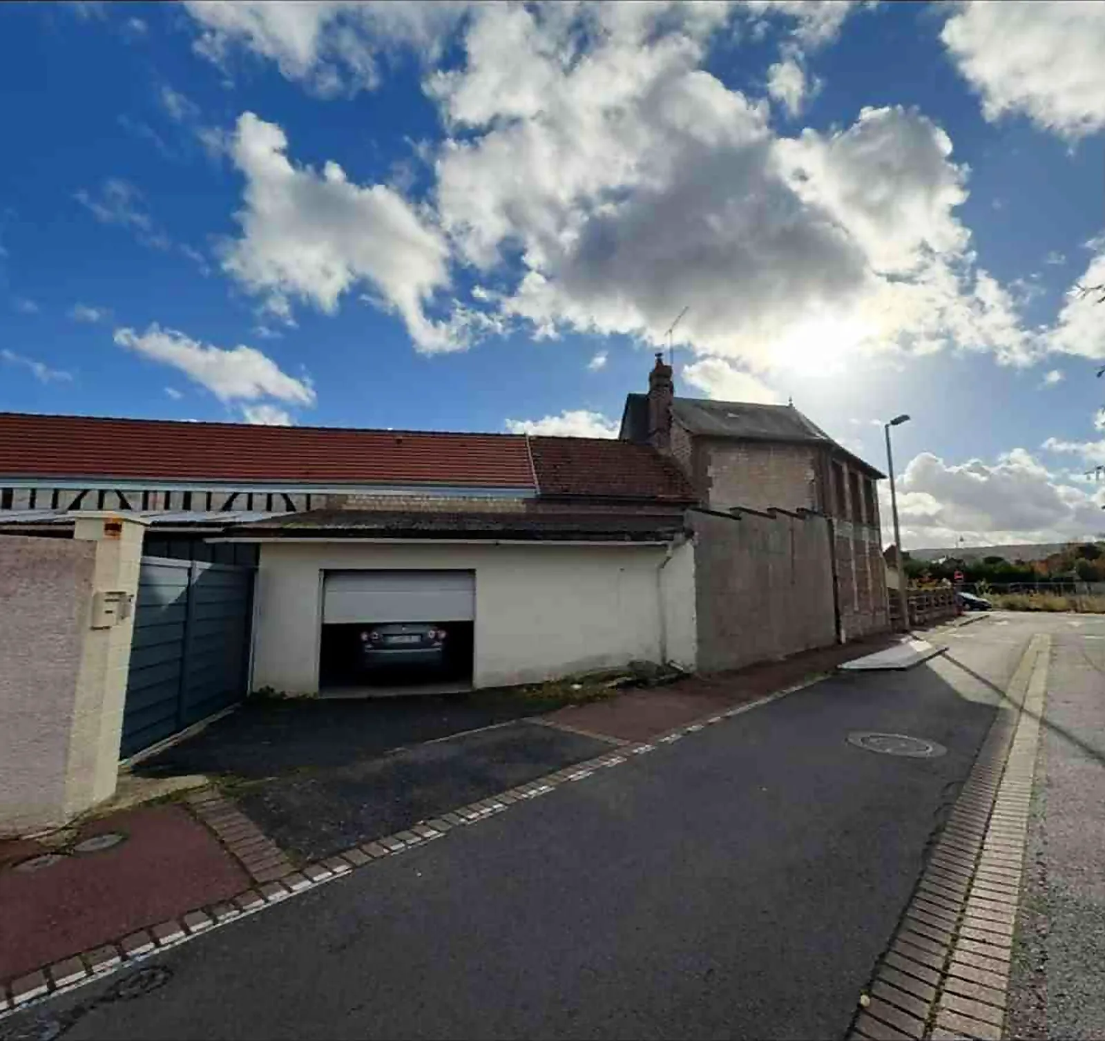 Vue depuis la rue d'un garage dont la toiture a été changée à Elbeuf