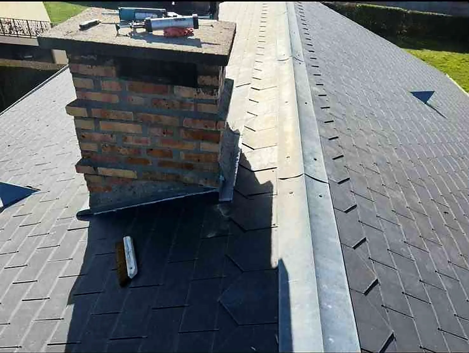 Vue d'ensemble d'une toiture en ardoises avec cheminée et raccords en zinc